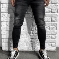 מכנס ג'ינס שחור עם כמתים באזור הברכיים. תמונה של איזור המכנס